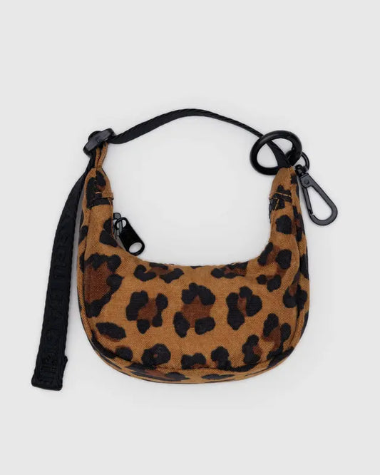 Leopard print handbag with a black strap on a light gray background