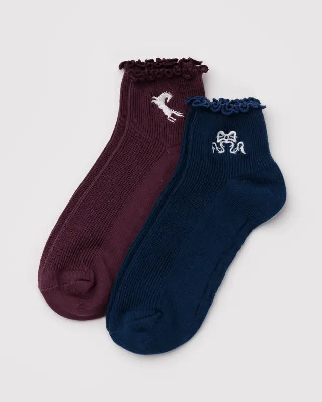Two pairs of socks, one maroon and one navy, with a horse and a bow embroidered on a light gray background.