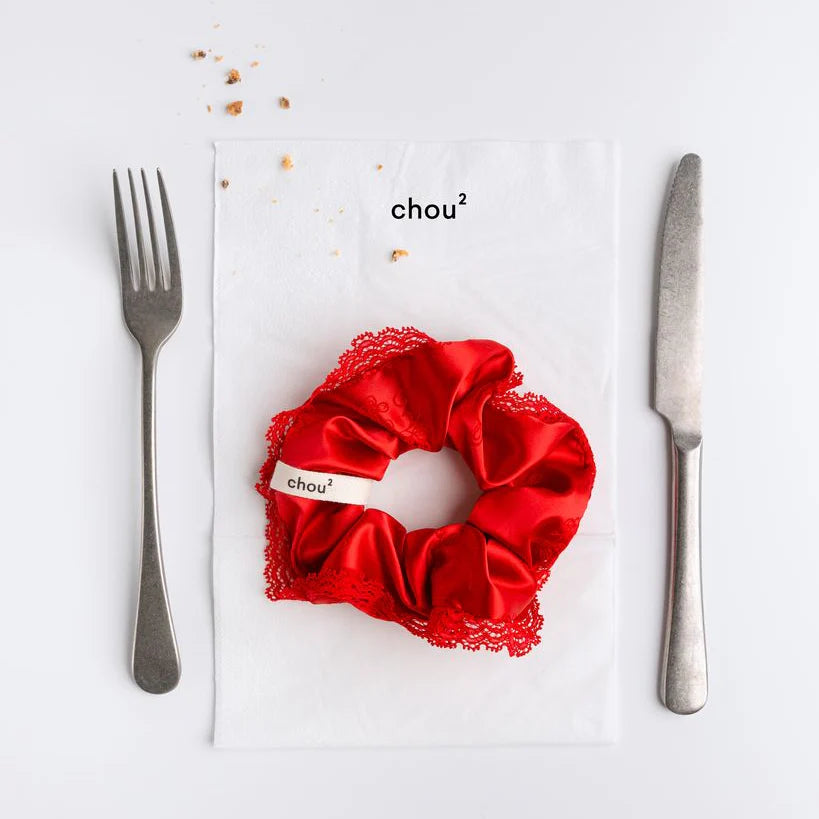 Red hair sating scrunchie with lace detailing on a white background
