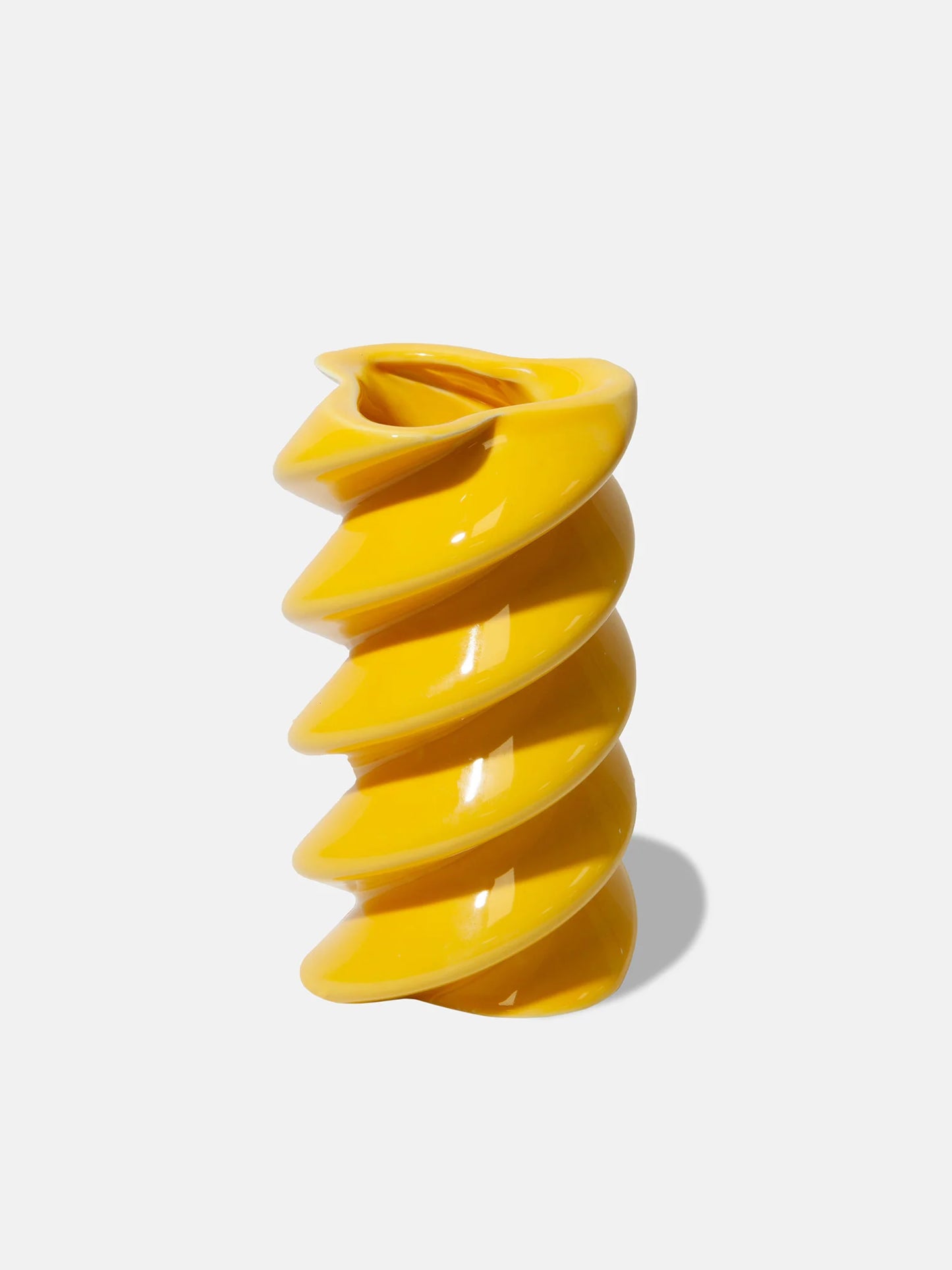 Yellow spiral-shaped pasta vase on a white background