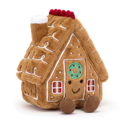Plush gingerbread house toy with a smiley face on a white background