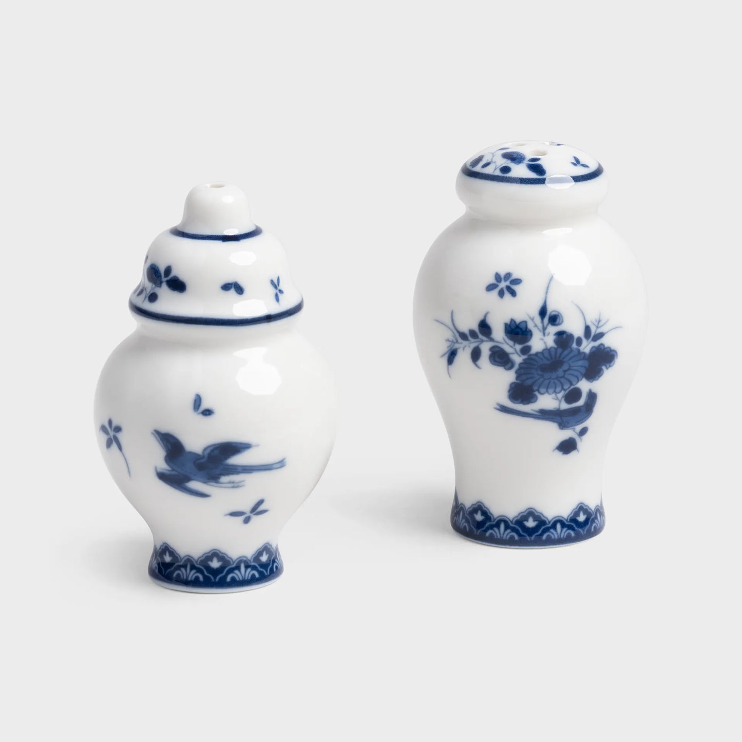 Two white ceramic jars with blue floral patterns on a light gray background