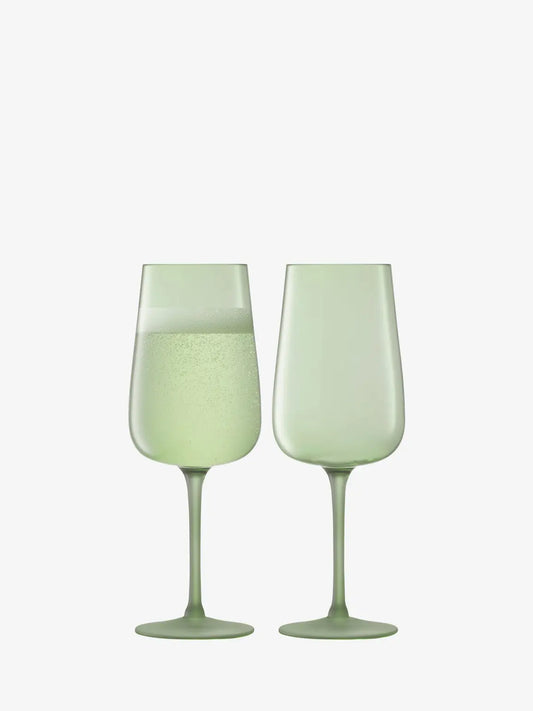 Two light green flute glasses on a white background