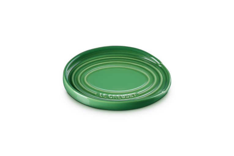 Green ceramic spoon rest plate on a white background
