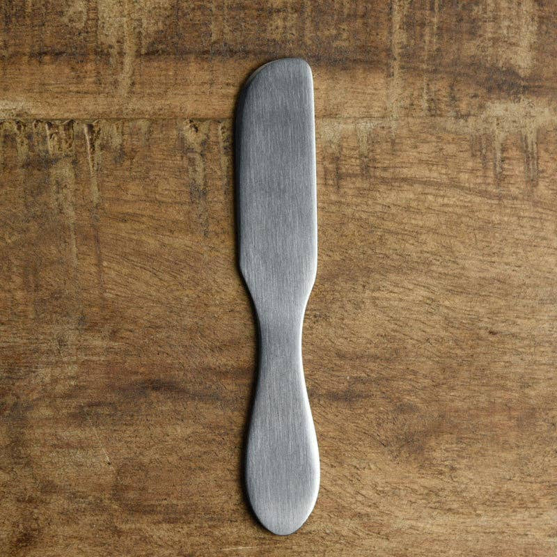 Metal butter knife on a wooden surface