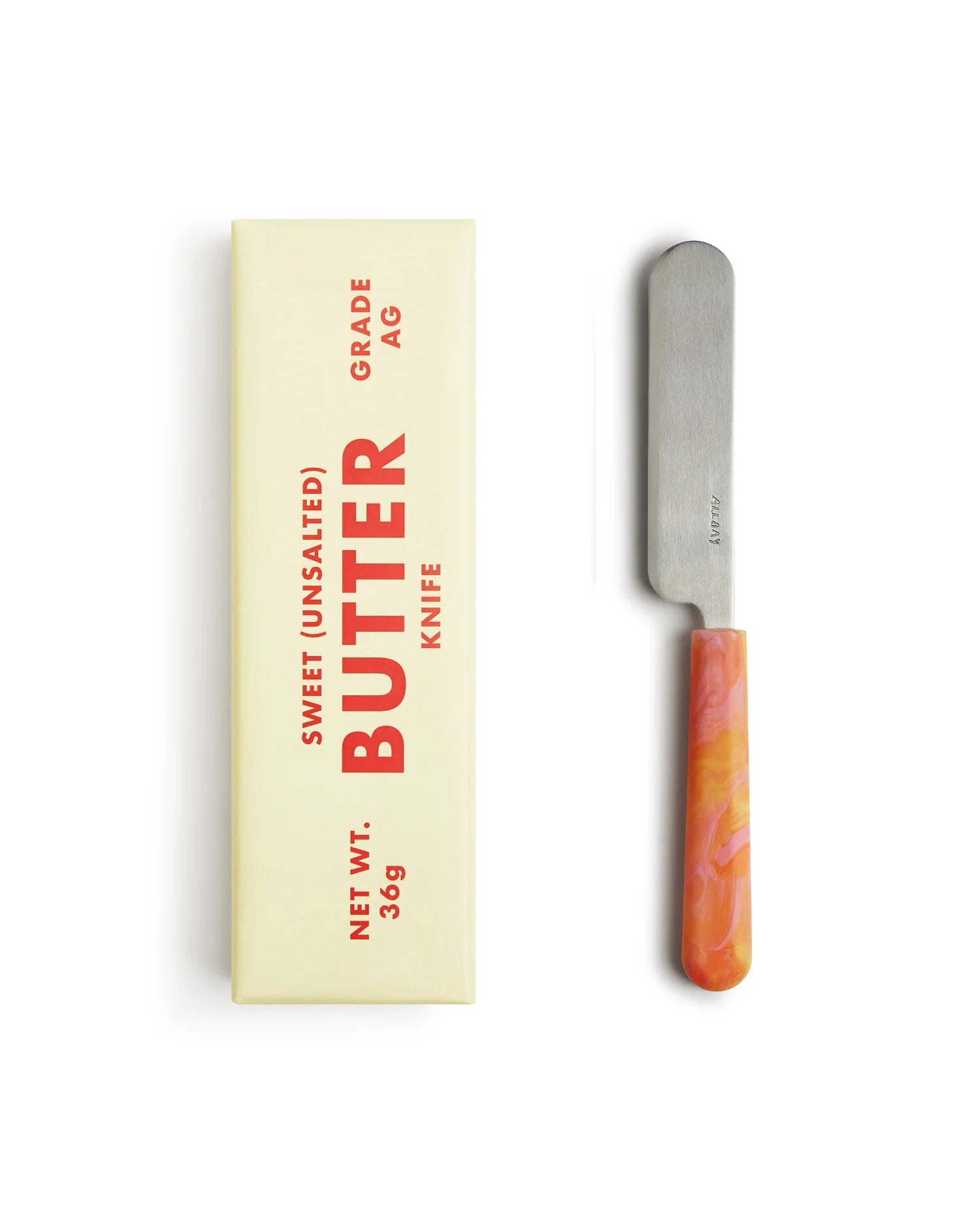 Butter knife with marbled handle next to its packaging on a white background