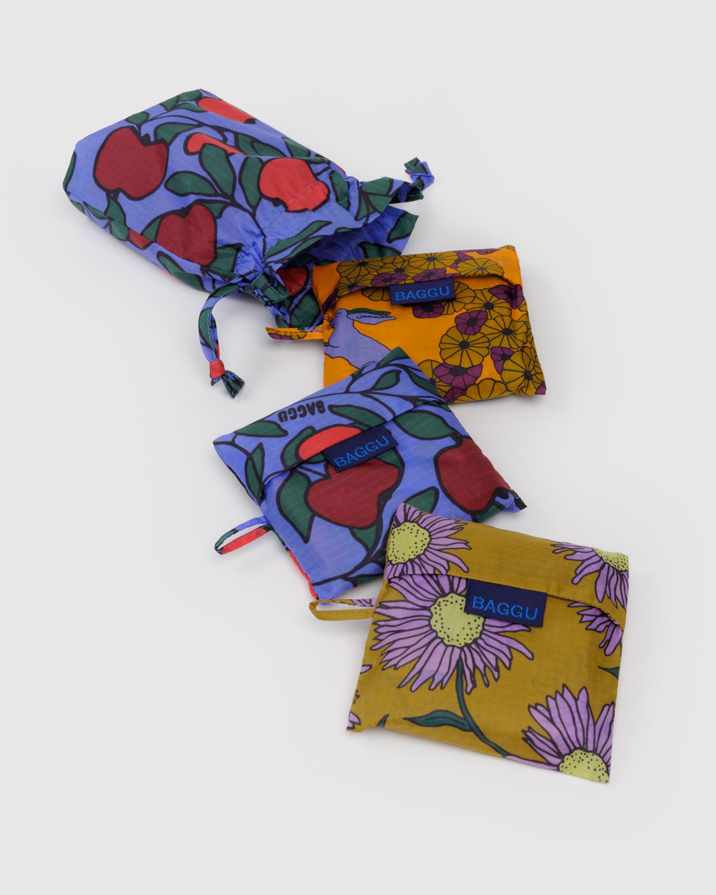 Set of colorful fabric bags with floral and fruit patterns on a white background