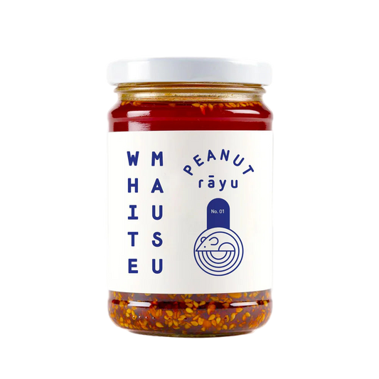 Jar of peanut rayu with a white label on a white background