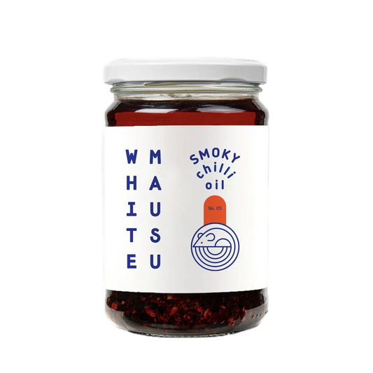Jar of smoky chili oil with a white label on a white background