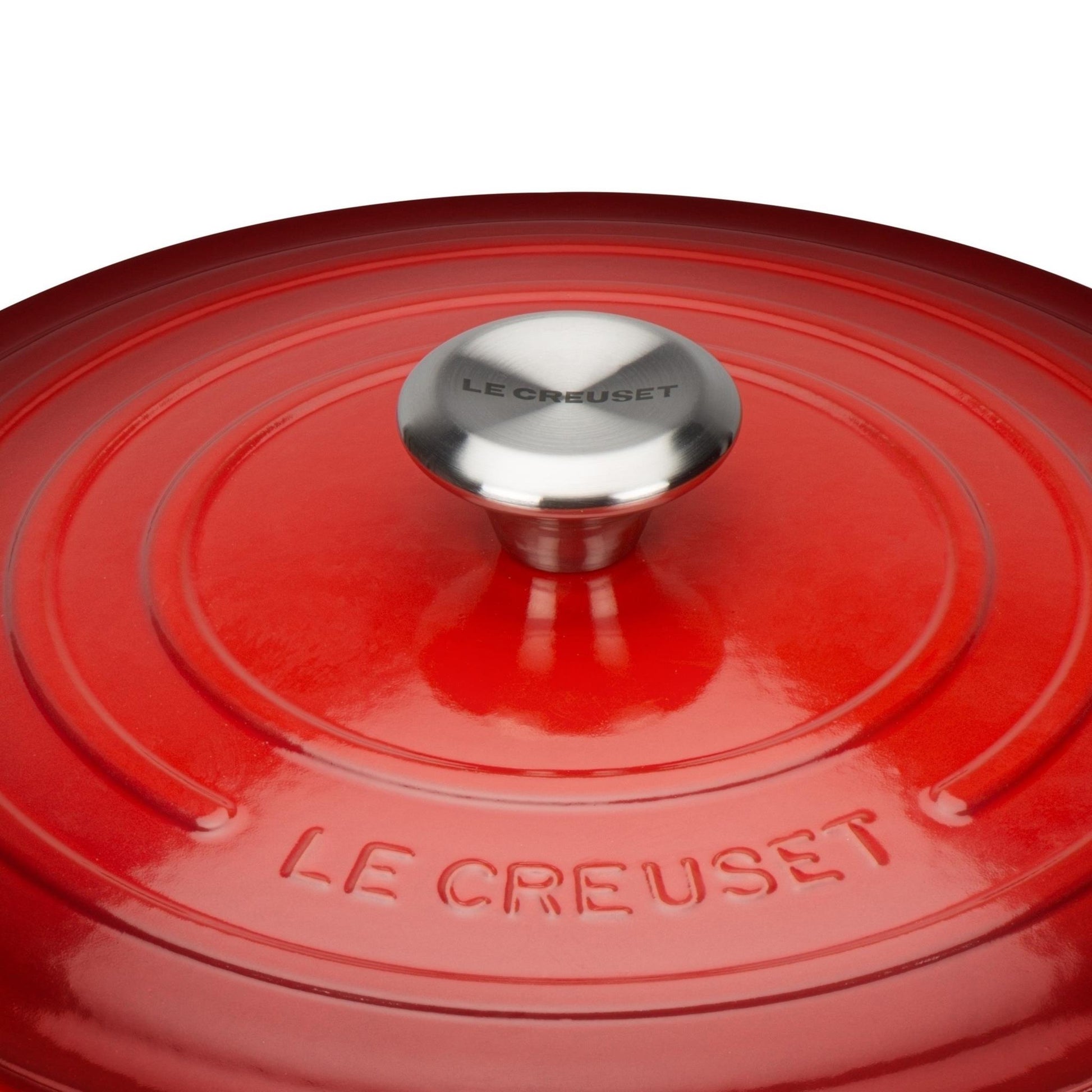 A close up of the pot lid with the le crueset logo embossed and the branded pot handle