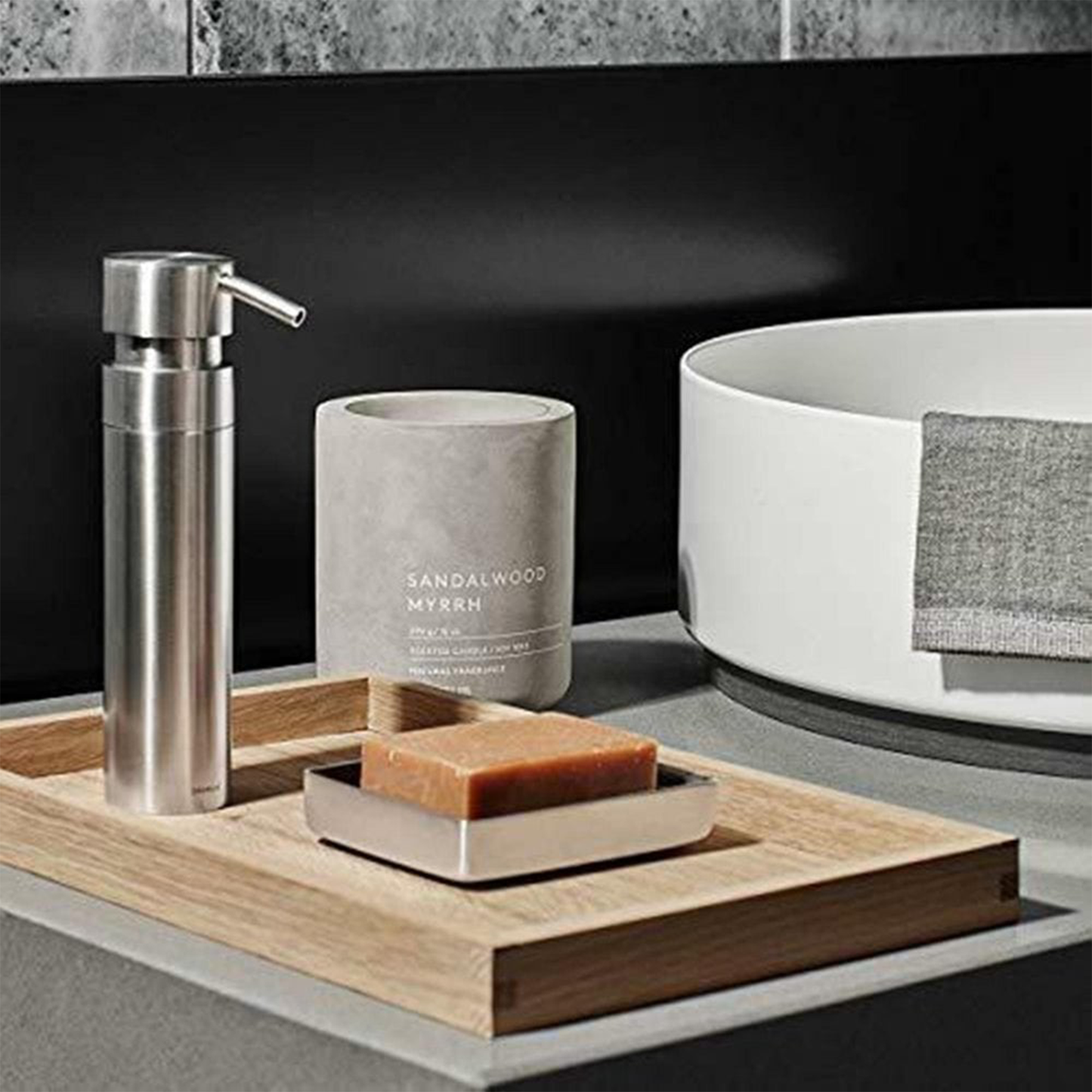 a sandlewood and myrrh candle displayed on a bathroom counter