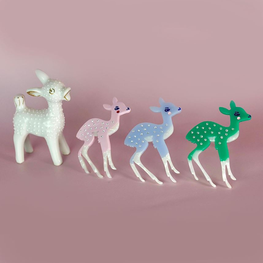 three deer hair clips on a pink background