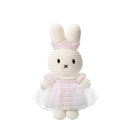 Crocheted bunny toy in a pink dress on a white background