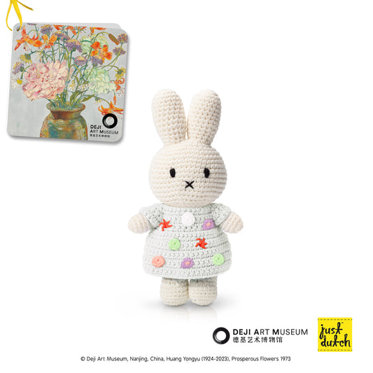 Crocheted rabbit toy with a dress in front of a painting, with Dejih Art Museum logo.