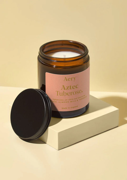 Aery Aztec Tuberose candle in a glass jar with a pink label