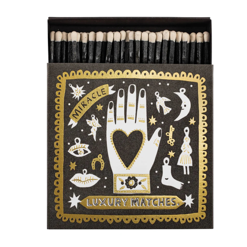 Matches with decorative packaging featuring a hand with a heart and celestial symbols.
