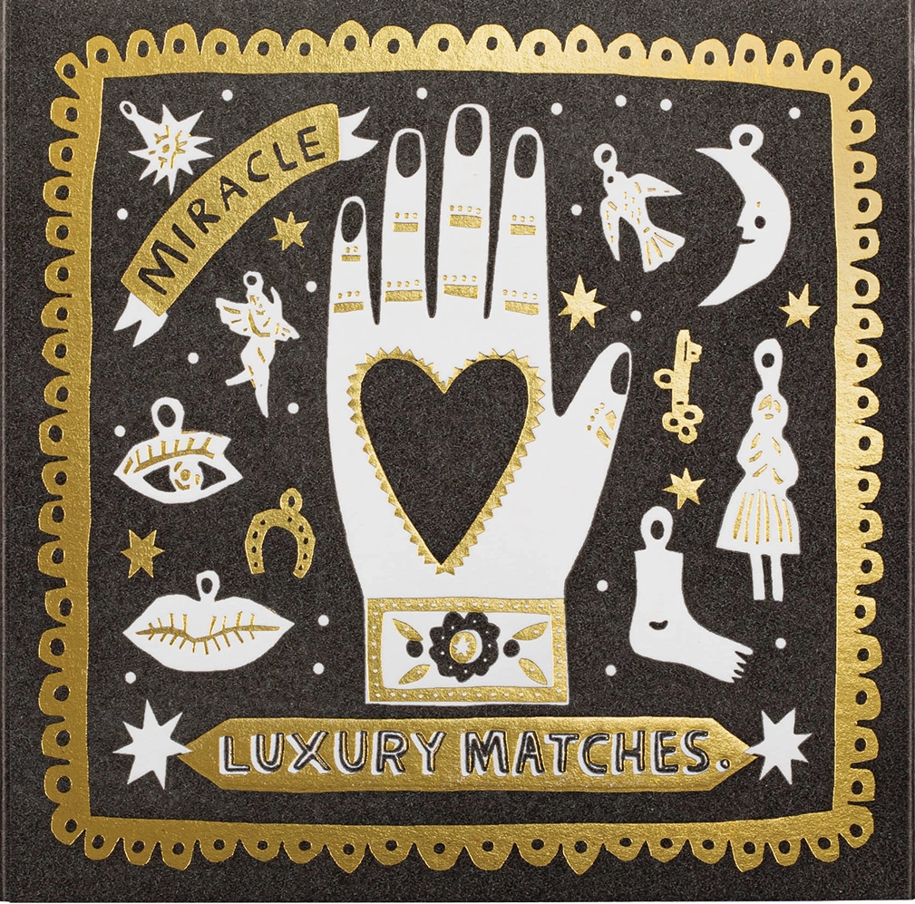 Decorative matchbox with hand, heart, and mystical symbols on a black background