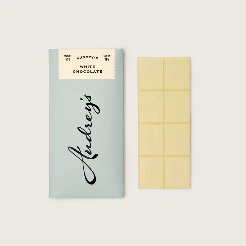 Lindt white chocolate bar with packaging on a light gray background