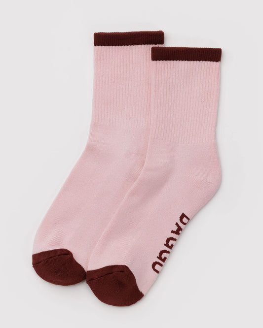 Pair of pink socks with brown accents on a light gray background