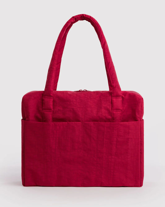 A vibrant magenta-red fabric tote bag with two top handles and a front pocket, shown against a neutral light gray background.