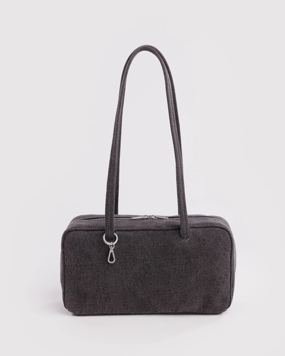 Black handbag with a strap on a light gray background