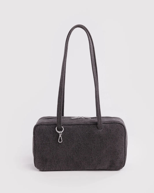 Black handbag with a strap on a light gray background