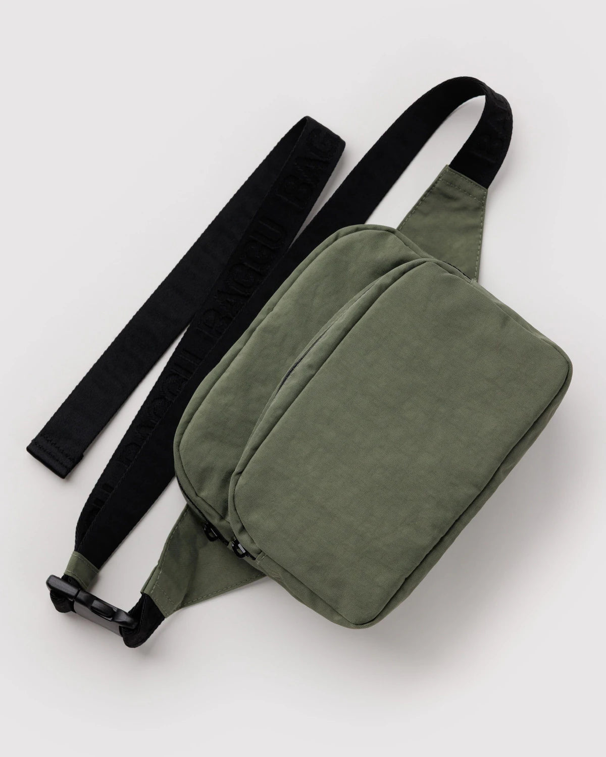 Green waist bag with a black strap on a white background