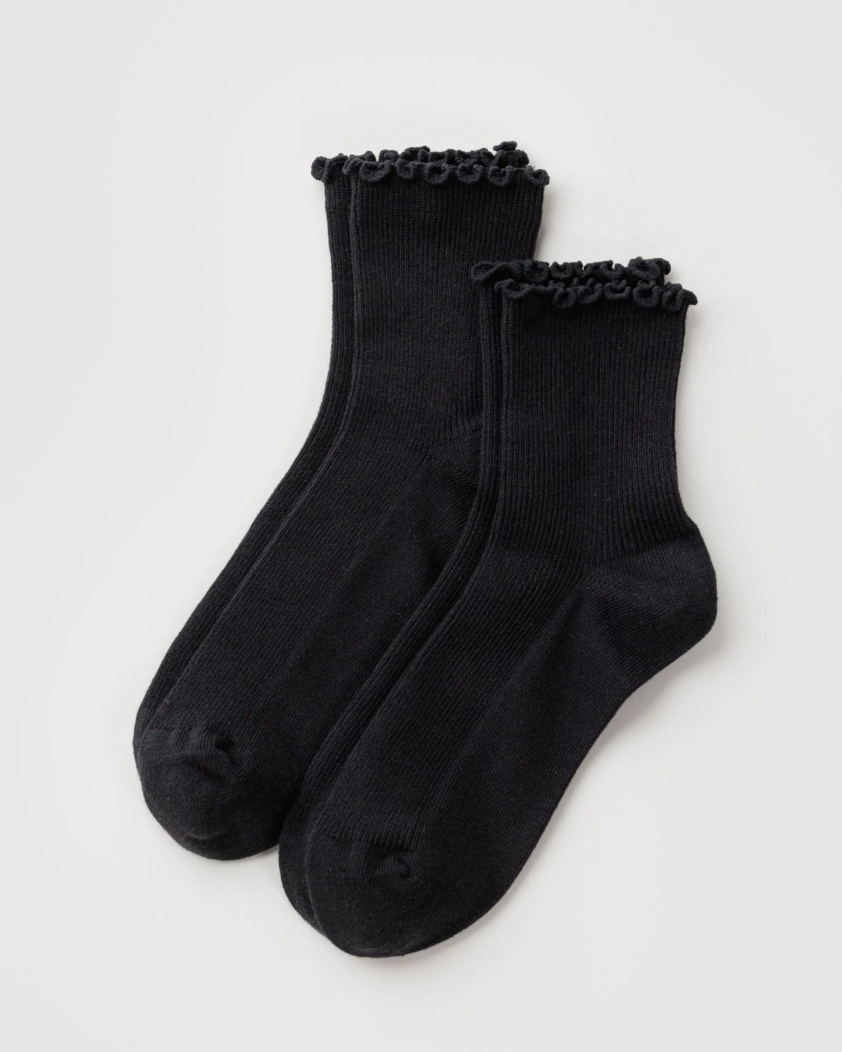 A pair of black crew socks with decorative ruffled trim at the top, displayed on a light gray background.
