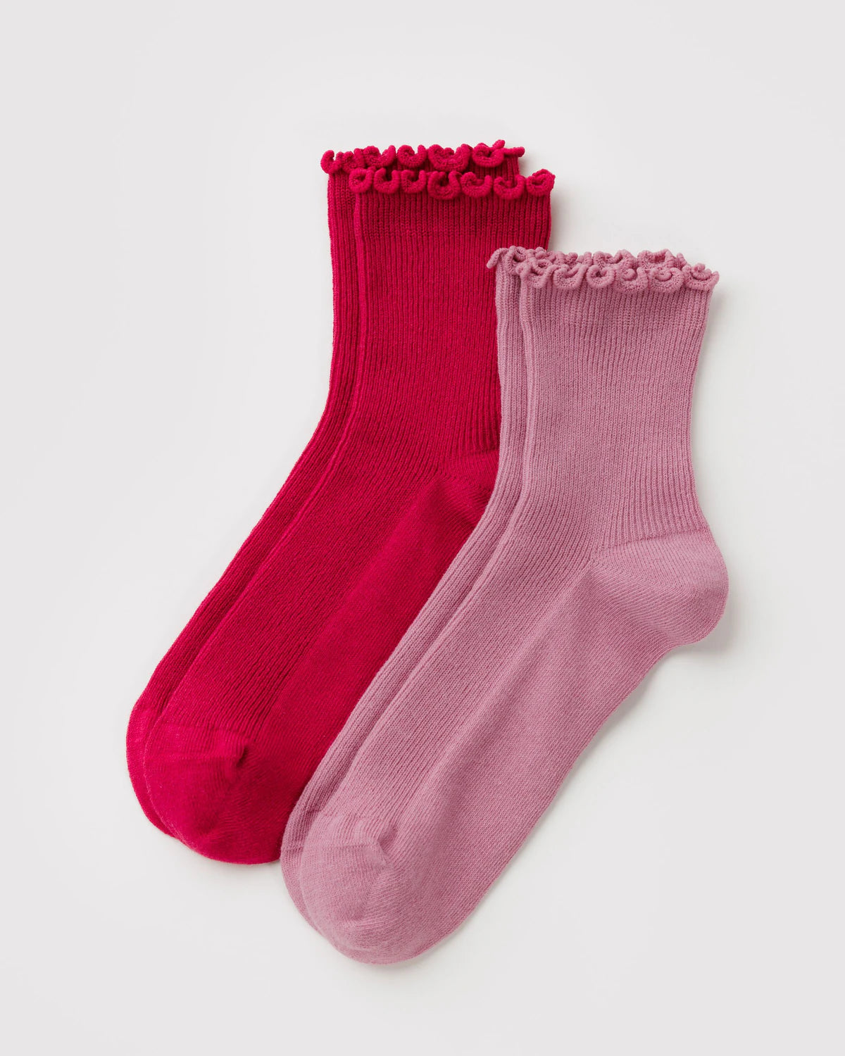 Two pairs of socks, one red and one pink, with decorative top ruffles on a light gray background.