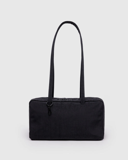Black handbag with a strap on a light gray background