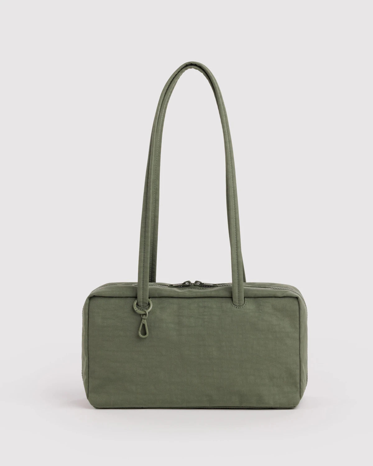 Green handbag with a long handle on a light gray background