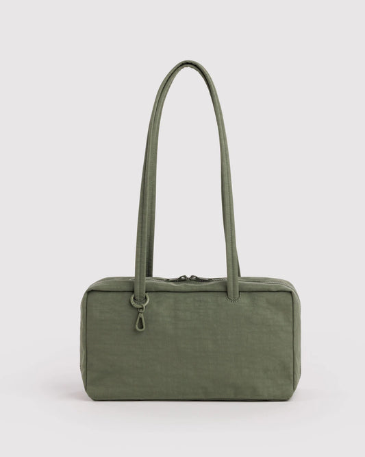 Green handbag with a long handle on a light gray background