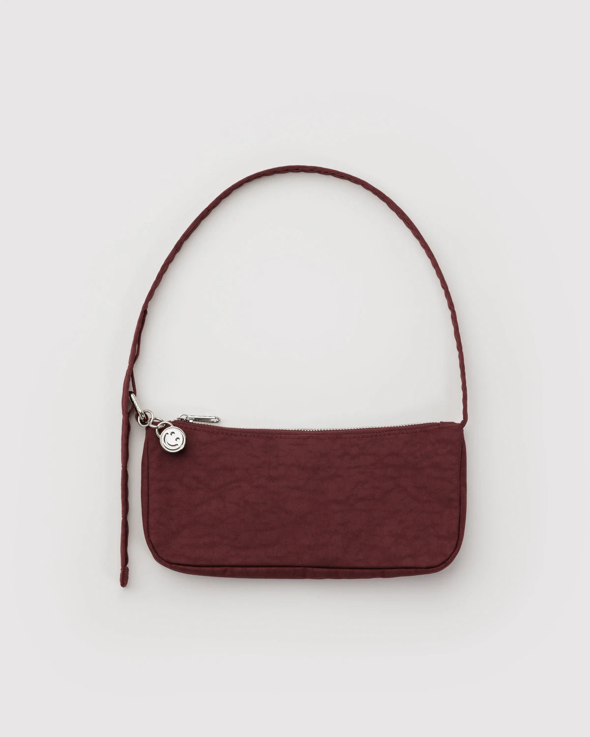 Maroon handbag with a strap on a light gray background