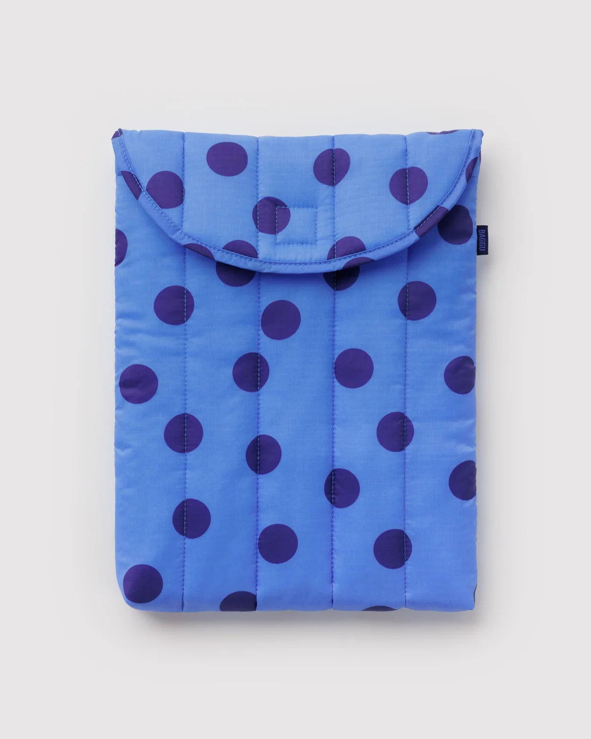 A blue quilted pouch or sleeve with a dark purple polka dot pattern, shown flat against a light gray background.
