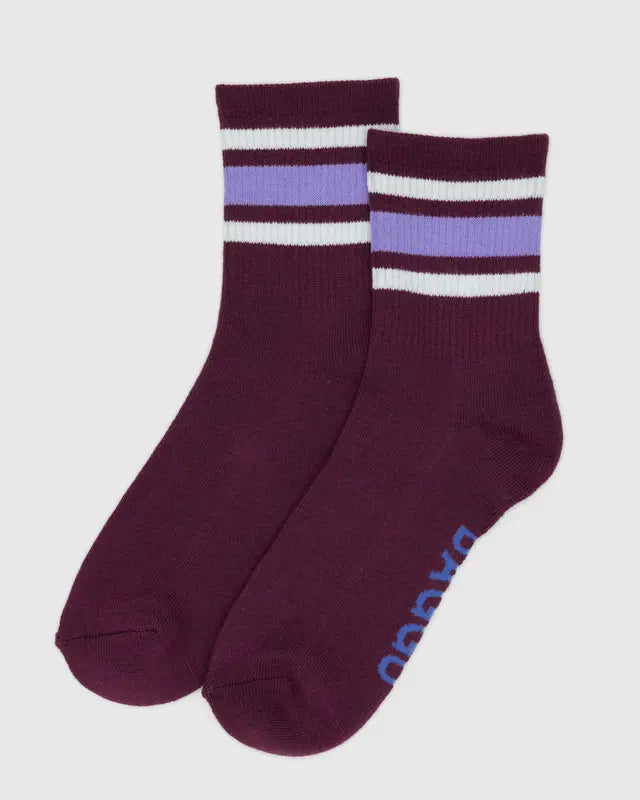 Pair of maroon socks with white and purple stripes on a light gray background