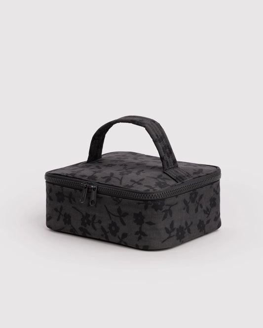 Black floral-patterned travel case on a light gray background