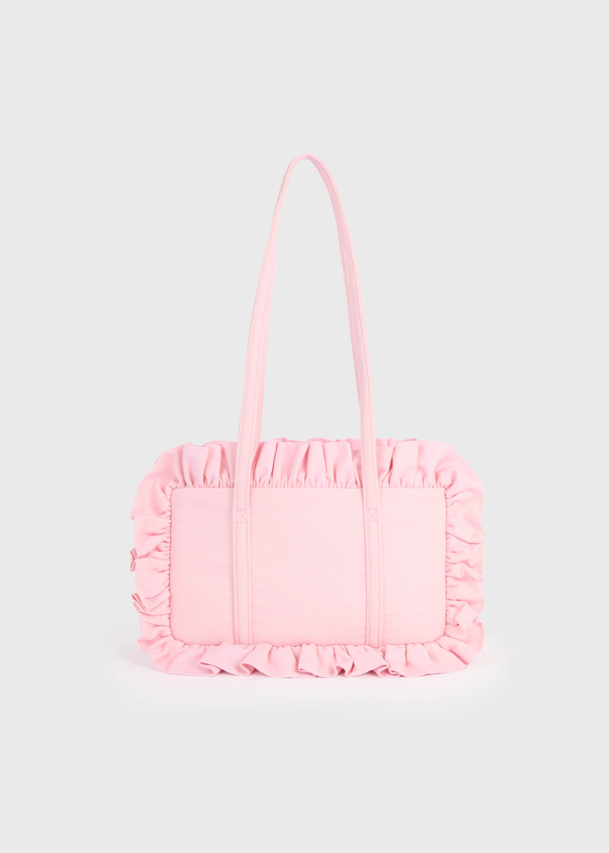 Pink handbag with ruffled details on a light gray background