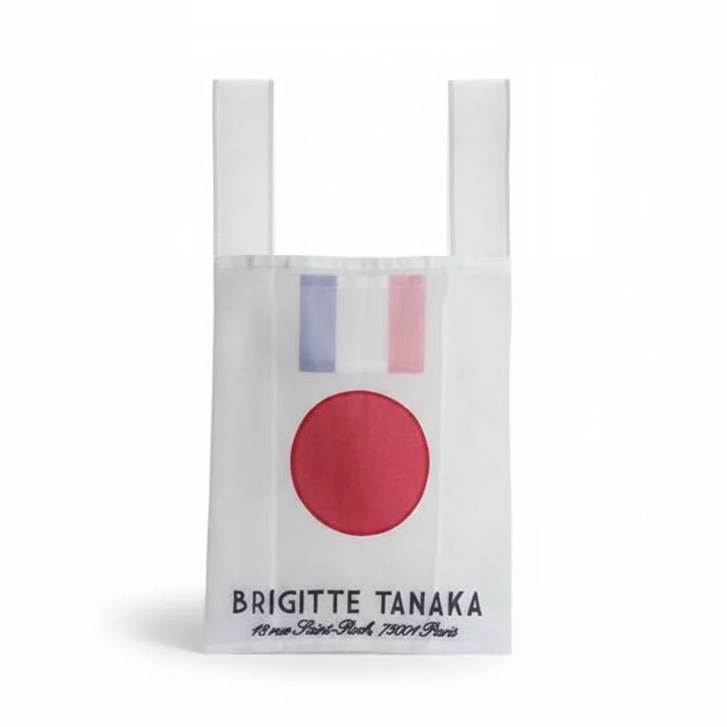 White tote bag with red circle and blue and pink stripes, featuring 'Brigitte Tanaka' branding.