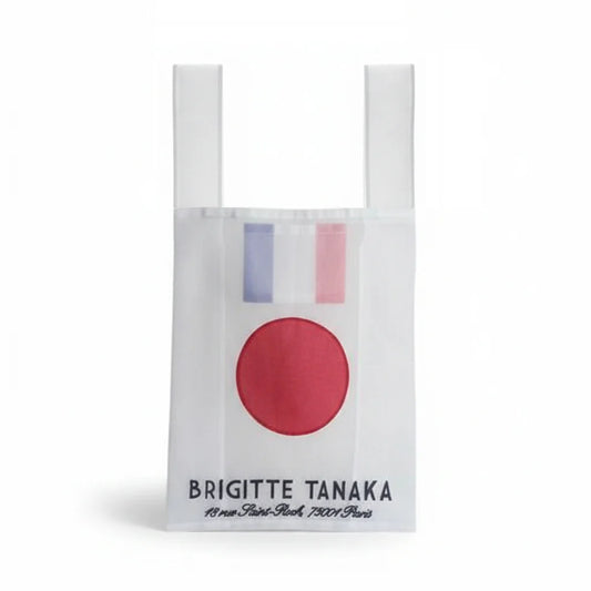 White tote bag with red circle and blue and pink stripes, featuring 'Brigitte Tanaka' branding.