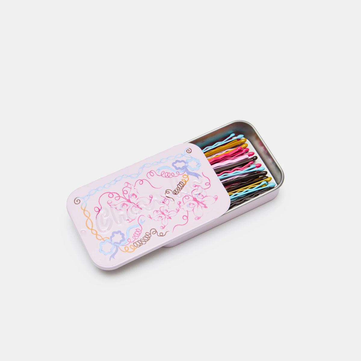 Metallic tin with colorful items on a light gray background