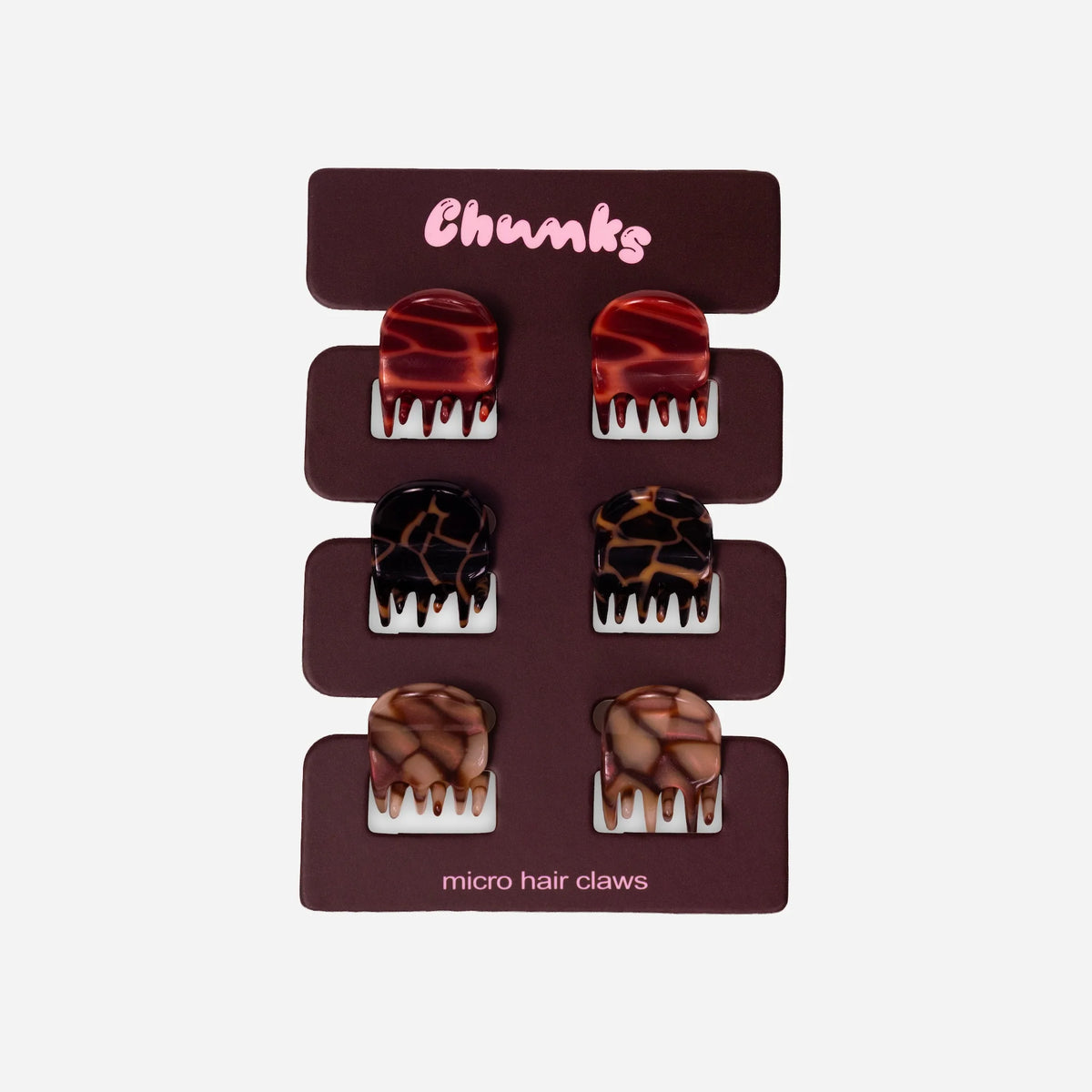 Six micro hair claw earrings displayed on a dark brown backing card labeled 'Chunks' with 'micro hair claws' at the bottom. The earrings feature marbled and textured designs in red, black-and-brown, and brown tones.