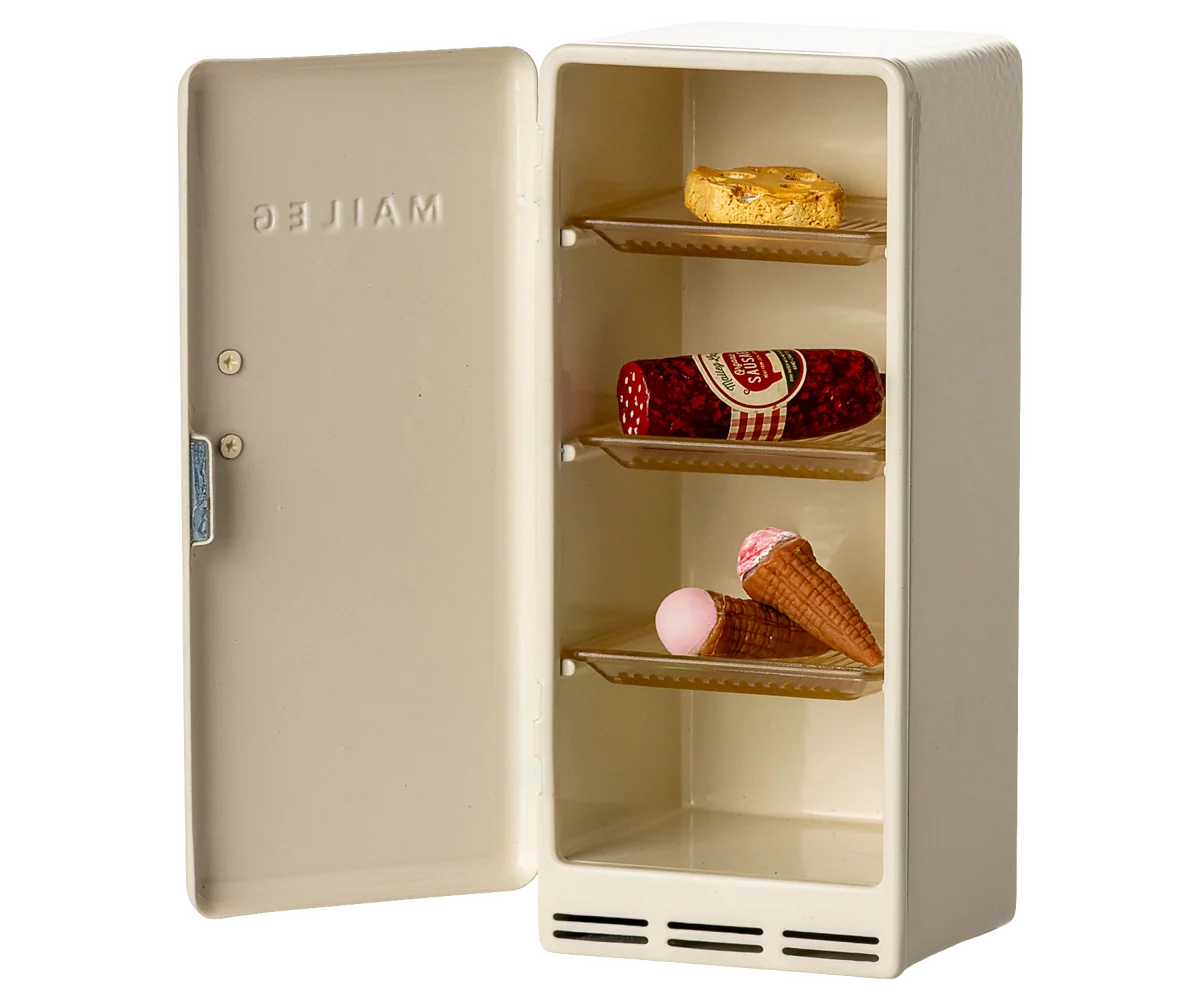 Inside of the toy vintage maileg fridge on a white background 