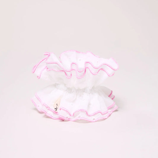 White lace doily with pink trim on a light gray background