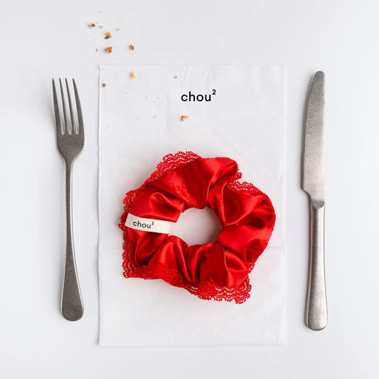 Red hair sating scrunchie with lace detailing on a white background