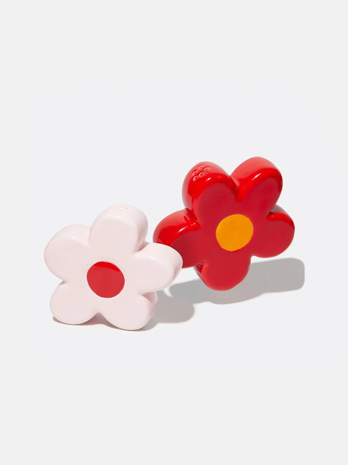 Ceramic pink and red daisy flower shaped salt and pepper shakers on white background