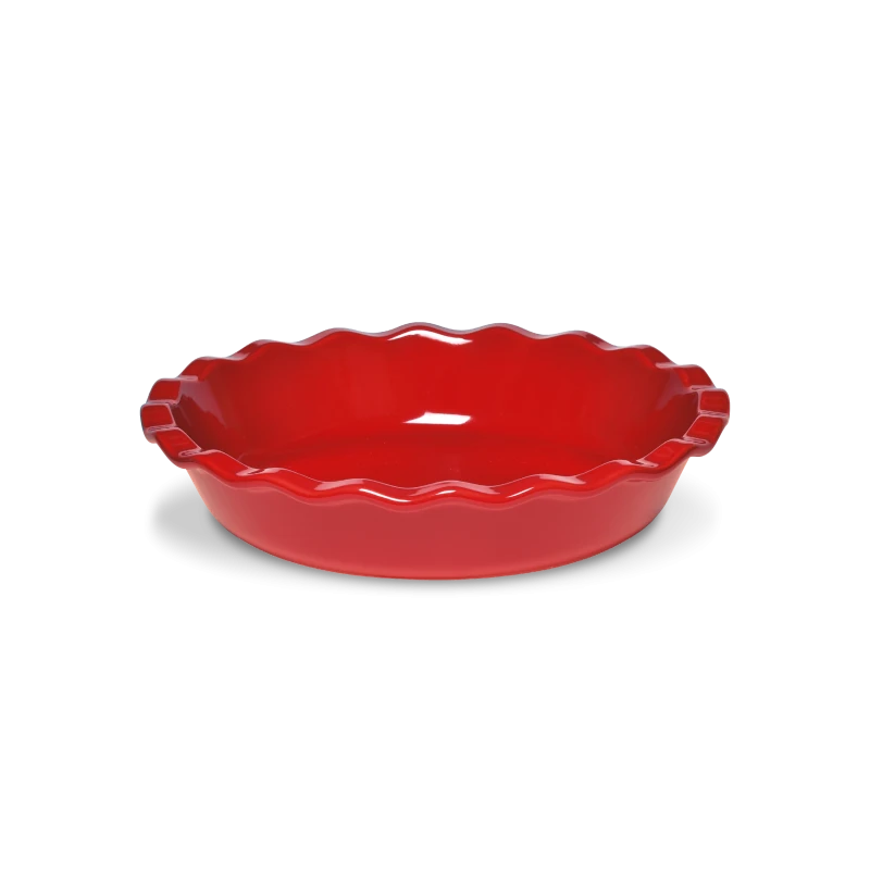 Red ceramic pie dish with scalloped edge on a white background