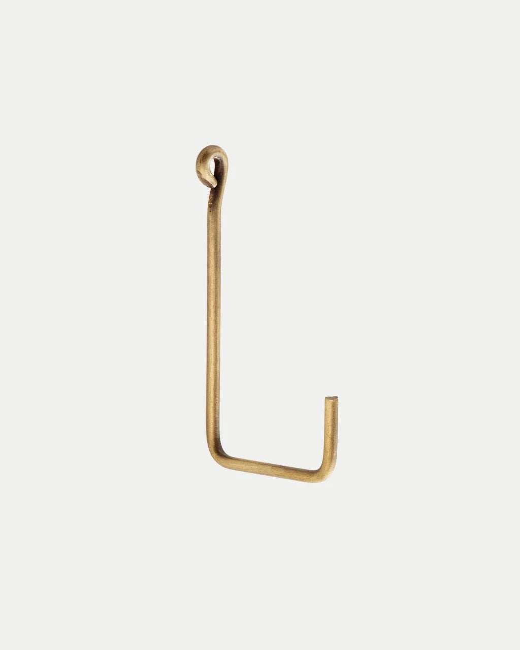 A single L-shaped metal wall hook in a warm brass or gold finish, shown against a solid off-white background.