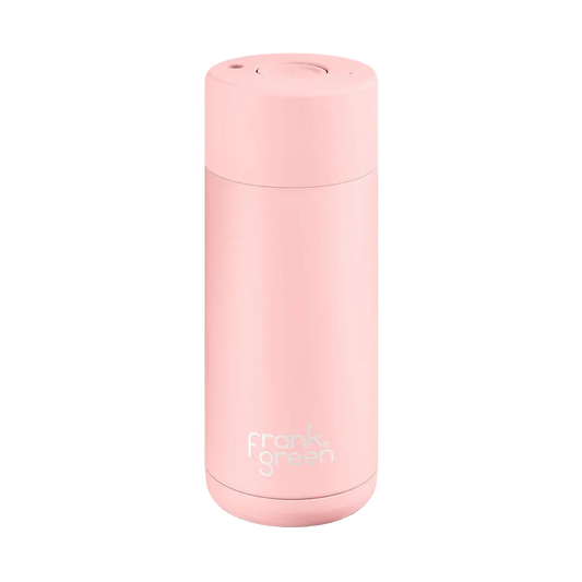 A light pink vacuum-insulated travel tumbler with a matching lid, featuring the 'frank green' logo near the bottom, set against a plain white background.