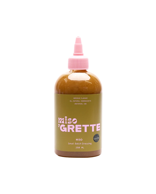 Bottle of Miso Grette dressing with a pink cap on a white background