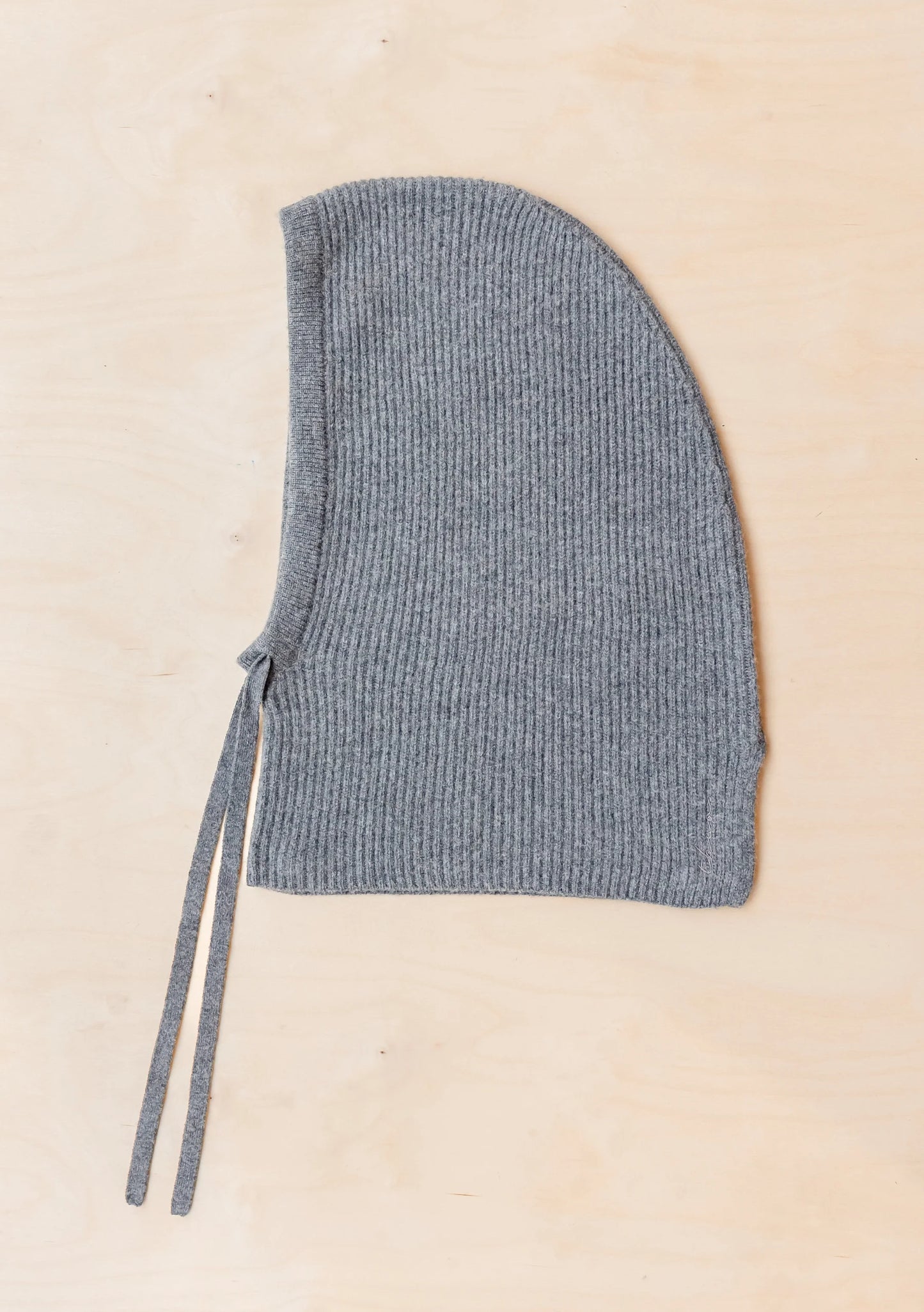 Knitted bonnet with a strap on a beige background